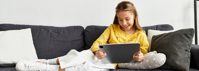 Girl relaxes in a cozy home environment while enjoying her tablet