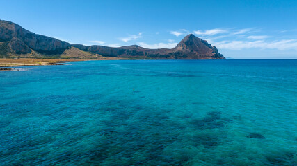 Fototapeta premium Panorama of Cofano Mount located in the province of Trapani, Sicily, Italy. A mountain in the background and the turquoise sea in the foreground.