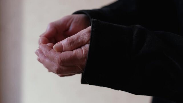 Close-up of an elderly woman's outstretched hands begging for alms