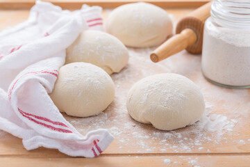 Pieces of raw bread dough  on wooden kitchen table, baking bread or pizza