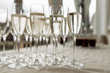 Close-up of elegant champagne flutes filled with sparkling wine, ready to be served at a festive wedding reception or event
