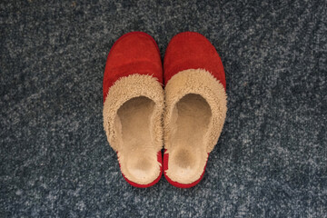 Pair of well worn red fuzzy slippers