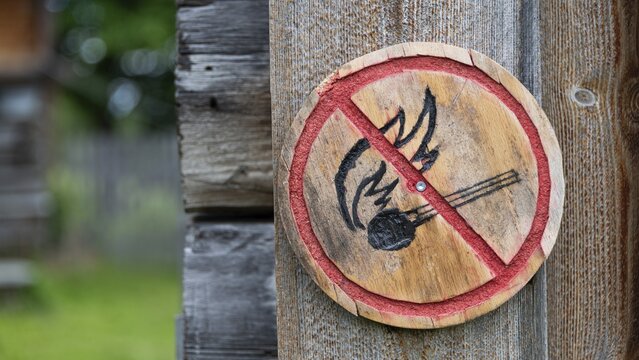 Brennendes Streichholz, kleine runde Holztafel mit aufgemaltem Verbotssymbol gegen das Entfachen von Feuer, historischer Bauernhof und Pilgerunterkunft Budsjord, Dovre, Pilgerweg Olavsweg oder Olavsleden, Gudbrandsdalen oder Gudbrandstal, Norwegen