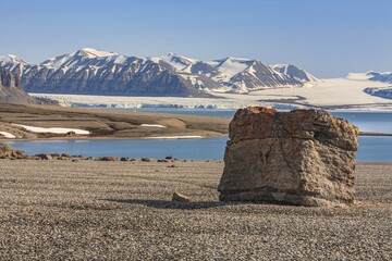 Boulder, rocks, glacier and mountains behind, sunny, 14 July glacier, Svalbard, Norway