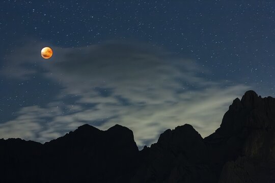 Complete lunar eclipse in front of mountains at night, full moon, Karwendel Mountains, Bavaria, Germany