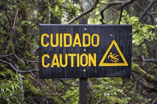 Warning sign Cuidado Caution, Attention danger of slipping, in the forest, Po&aacute;s National Park, central highlands, Alajuela province, Costa Rica