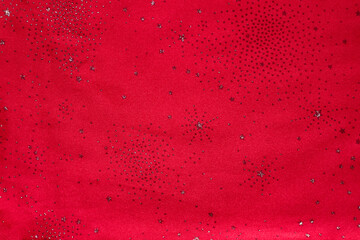 Red glitter background with silver stars and specks for festive design and decor