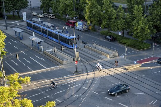 View from above of a road crossing with tram and tram stop, cyclist and a car crossing the crossing, Stiglmaierplatz, Munich, Upper Bavaria, Bavaria, Germany