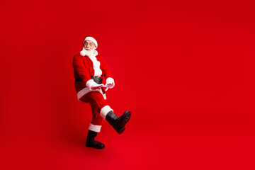 Santa dances in a classic costume against a bold red background for Christmas campaigns and holiday creativity