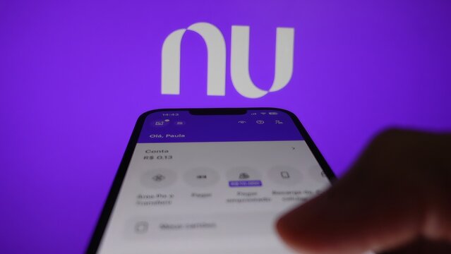 S&atilde;o Paulo, Brazil - January 27, 2025: A hand scrolls across a smartphone while using the Nubank app, one of the largest digital banks in Brazil.