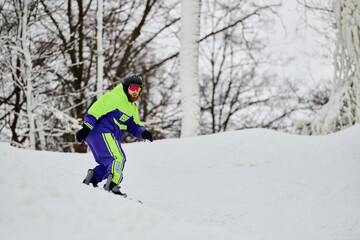 Bearded man enjoys snowboarding on a winter slope covered in fresh snow