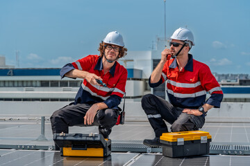 Solar engineer teamwork maintenance energy on rooftop project as two technician collaborate with tool and radio during panel service under daylight, focused and professional mood