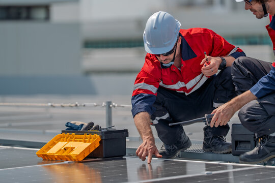 Solar engineer teamwork maintenance energy rooftop inspection bright sun as two worker adjust panel wiring with careful focus and calm pride during preventive service for reliable power supply - Powered by Adobe