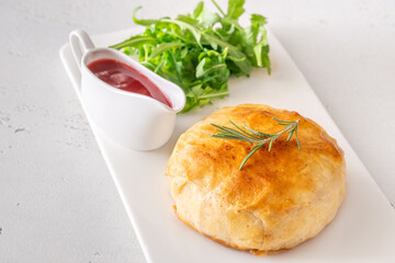 Golden Camembert en Croûte with rosemary sprig and deep red cranberry sauce
