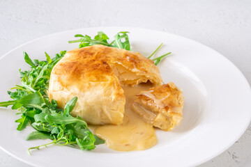 Melted Camembert en Croûte with rosemary garnish and vibrant cranberry sauce accompaniment