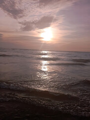 Fototapeta premium Sunset over the ocean with waves and colorful sky