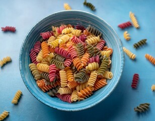 colorful pasta shapes in a light blue bowl showcasing a variety of twisted and spiral designs perfect for culinary presentations and food styling concepts