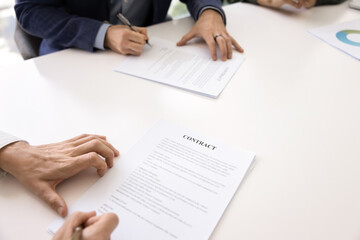 Two male business partners signing contract for collaboration