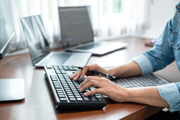 Close up of asian programmer woman holding pen and writing code with data website or data...