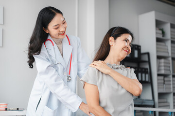 Fototapeta premium Asian Doctor Examining Older Patient Shoulder Pain Relief Consultation. Medical Professional Healthcare Treatment for Muscle Stiffness and Recovery Therapy