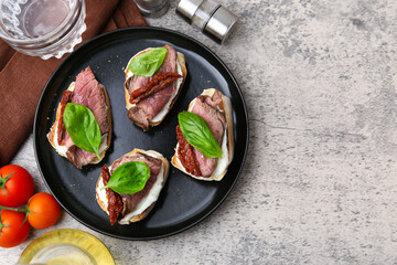 Bruschettas with roast beef served on grey table, flat lay. Space for text