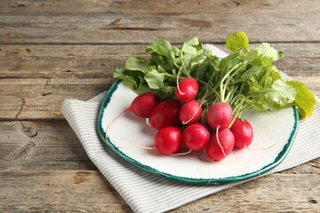 Fresh ripe radishes on wooden table, space for text