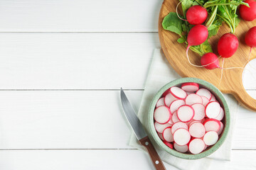 Fresh ripe radishes and knife on white wooden table, flat lay. Space for text