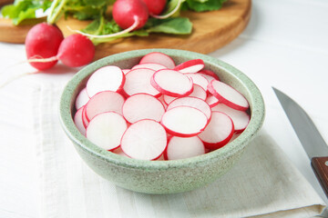 Fresh ripe radishes and knife on white table, closeup