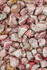 Red and white decorative garden stones with natural marbled texture forming a detailed ornamental surface