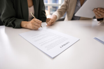 Hand of businesswoman pointing at place for signature in document