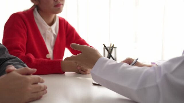 Couple attend fertility consultation with gynecologist at hospital as part family planning care for pregnancy. Husband and wife intently listen through the doctor appointment. Slow motion. Rigid.
