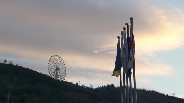 sunset sky tbilisi city center square flags park top ferris wheel up view slow motion panorama 4k georgia