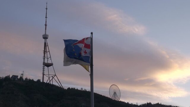 sunset sky tbilisi city center square flags park top tower ferris wheel up view slow motion panorama 4k georgia