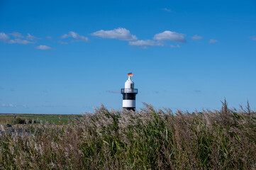 Small lighthouse in Wremen on the North Sea coast, with grasses in the foreground