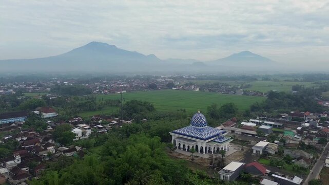 Aerial view of a beautiful mosque with Mount Kawi and Mount Arjuno in the background, Malang Regency, Indonesia