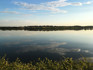 Sunny lake view with light green trees and blue sky. Tranquil landscape perfect for meditation. Breathtaking scenery of rural area Protect the planet Earth. Eco tourism. Travel to remote location