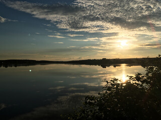 Beautiful sunset over the lake in the evening. Tranquil scenery in the countryside. Deep meditation in the nature. Magical hour of dim soft light for photography. Panoramic view of the pond.