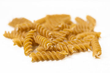 Spiral Brown Pasta on White Background, Close-Up Dry Pasta