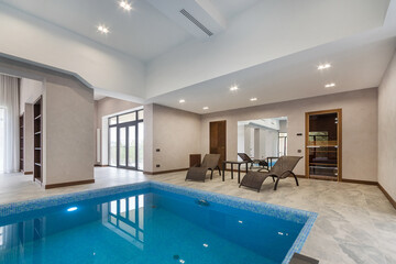 Modern interior design with swimming pool and relaxation area. Natural lighting creates an atmosphere of comfort and coziness.