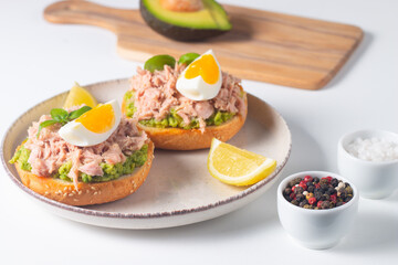 Two delicious tuna open sandwiches with avocado and boiled eggs. Tuna toast.