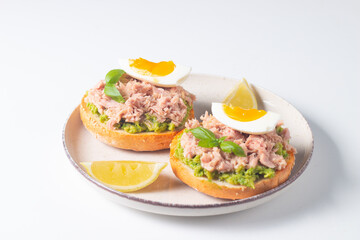 Two delicious tuna open sandwiches with avocado and boiled eggs. Tuna toast.