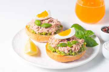 Two delicious tuna open sandwiches with avocado and boiled eggs. Tuna toast.