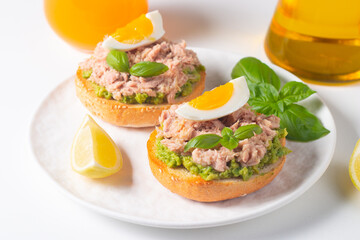 Two delicious tuna open sandwiches with avocado and boiled eggs. Tuna toast.