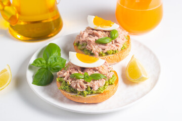 Two delicious tuna open sandwiches with avocado and boiled eggs. Tuna toast.