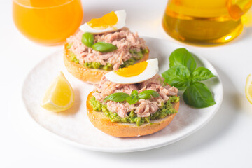 Two delicious tuna open sandwiches with avocado and boiled eggs. Tuna toast.