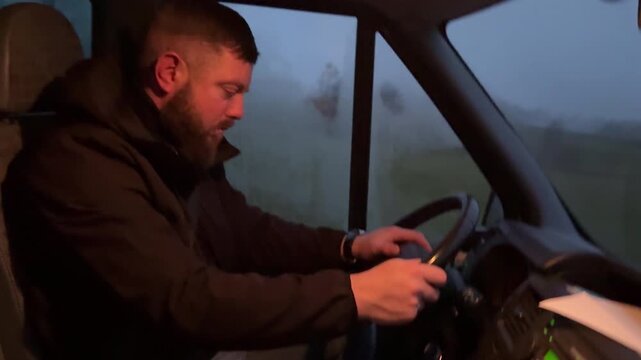 Tired man struggling to stay awake while driving a van in rainy twilight, fatigue and drowsiness behind the wheel, unsafe driving conditions