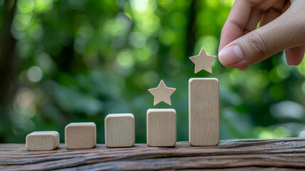 A hand places a star atop a wooden block completing a rising staircase of success.