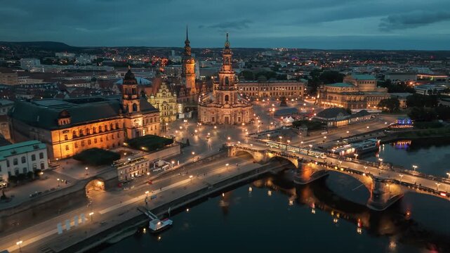 Aerial evening shot of Dresden, Germany. Cityscape of Dresden illuminated by evening lights along the Elbe River with historic architecture 