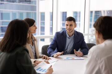 Confident positive company CEO man holding brainstorming meeting