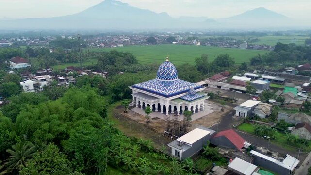 Aerial view of a beautiful mosque with Mount Kawi and Mount Arjuno in the background, Malang Regency, Indonesia
